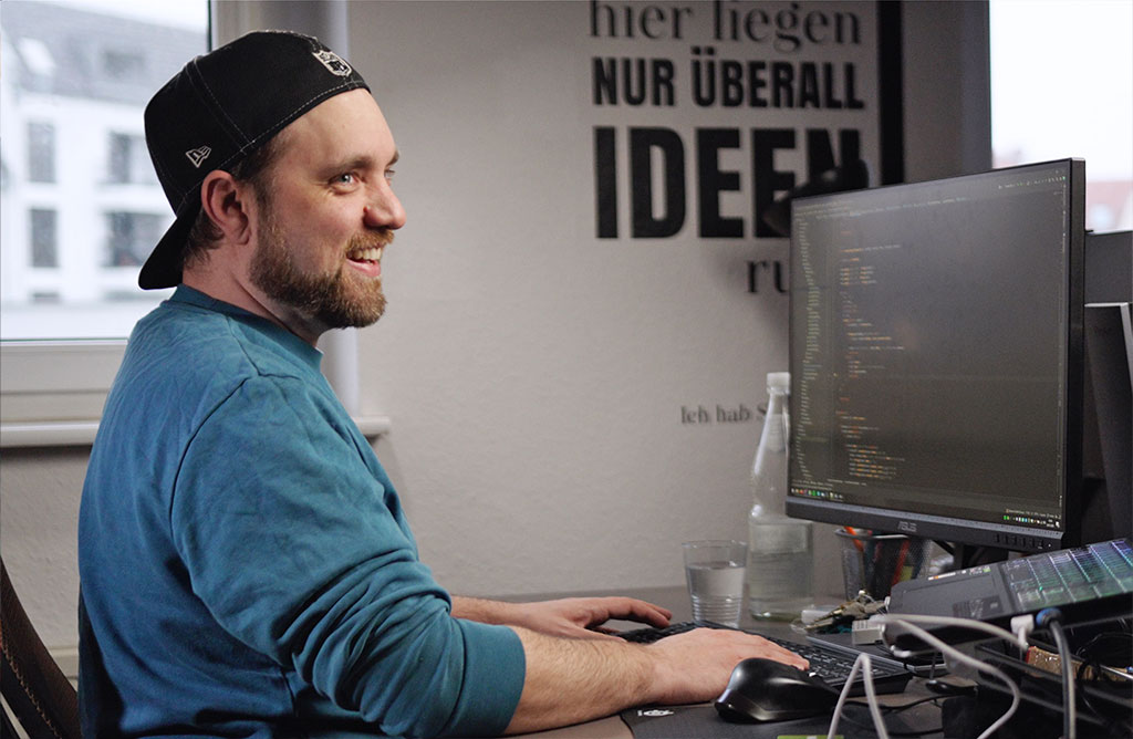Konzentrierte Arbeit am Schreibtisch mit Bildschirm und Programmcode – Entwicklung von Websites und Anwendungen